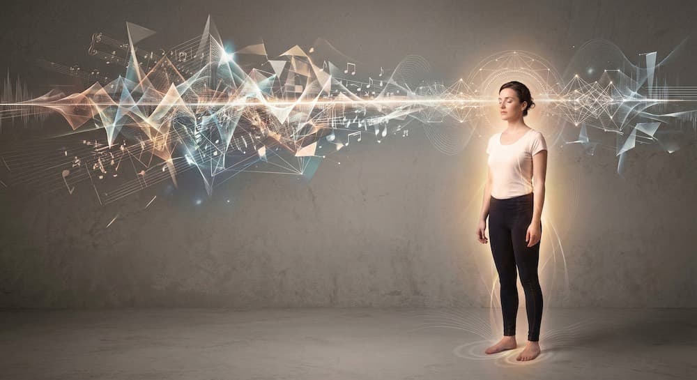 A figure standing in a beam of sound and notation